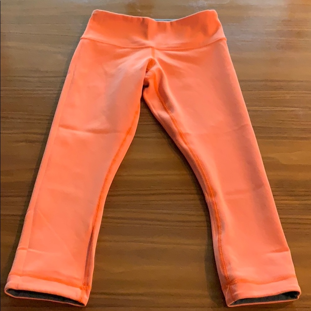 Orange Lululemon workout capris.